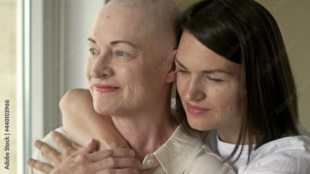 An adult daughter supports a mother with cancer in difficult times. An adult daughter supports a mother with cancer in difficult times.