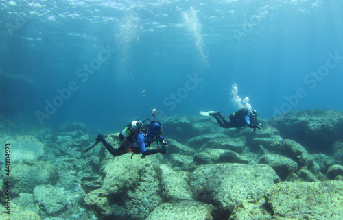 Diving instructor and student in underwater exercise. Instructor teaches student to dive. Underwater scuba diving education and training.