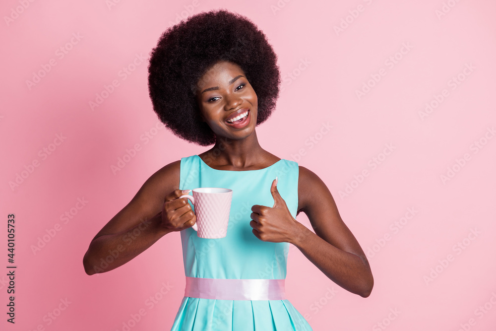 Photo of young happy positive smiling cheerful afro girl drink coffee show thumb-up isolated on pink color background Photo of young happy positive smiling cheerful afro girl drink coffee show thumb-up isolated on pink color background