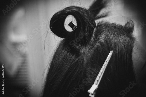 Side View of a Strand of Female Hair with a Clip. Close-up. Black and White image. Hair Styling Process.