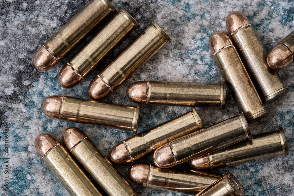 Brass handgun ammunition against a wooden backdrop