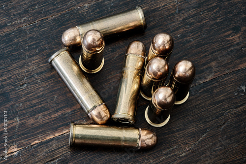 Brass handgun ammunition against a wooden backdrop