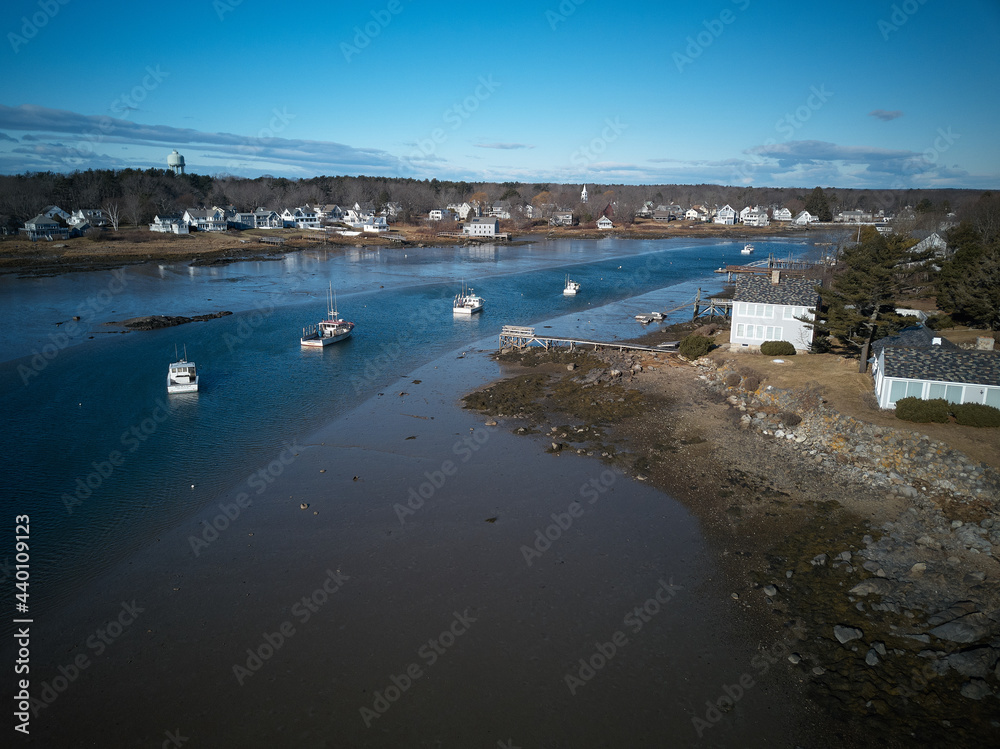 Aerial drone image of moored lobster boats in the deeper channel at low tide on the Maine Coast