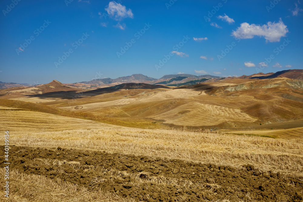 landscape of central sicily in the province of Enna in summer and clouds in the sky