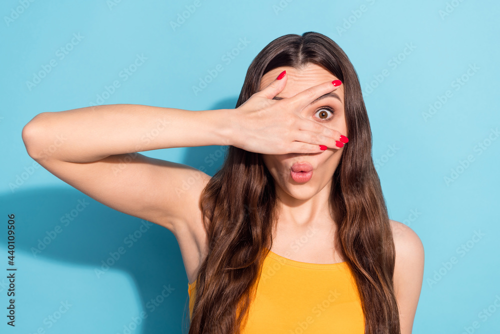 Photo portrait girl looking through fingers playful childish amazed surprised isolated pastel blue color background
