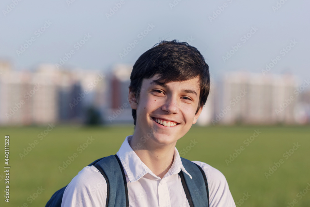 School teenager waiting for a school bus, on his way to school. On the way home from school against the background of the urban landscape School teenager waiting for a school bus, on his way to school. On the way home from school against the background of the urban landscape