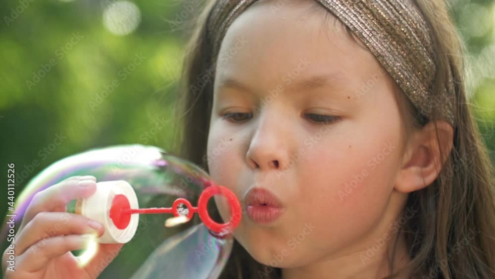 Close-up. The face of a child blowing a soap bubble. Close-up. The face of a child blowing a soap bubble.