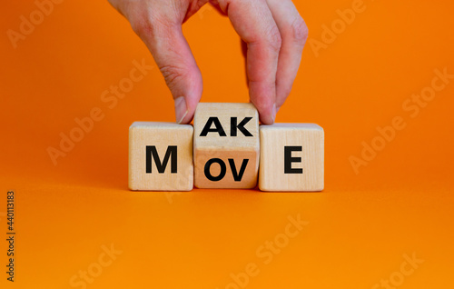Make your move symbol. Businessman turns the wooden cube with words 'Make move'. Beautiful orange background. Make your move and business concept. Copy space.