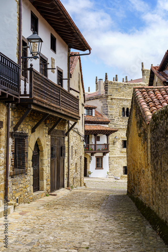 Narrow alley of old town in northern Spain with stone houses. Santillana del Mar.