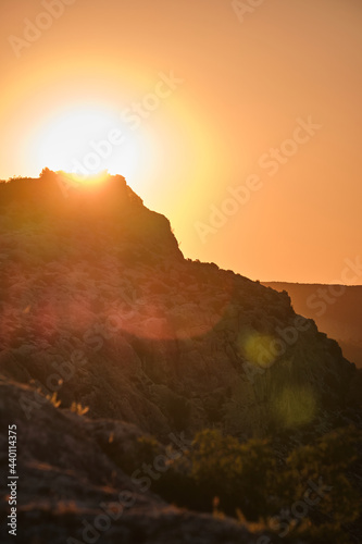 Beautiful view of a mountain landscape during sunrise. Orange sky and rocky mountains © Julian