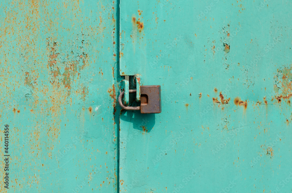 Vintage padlock. Steel door. Closed gate. Metal surface. Rusty metal.