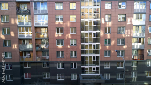 New residential building exterior with reflection of sun rays. Rising prices for purchase, sale and rental of real estate. Property. Inexpensive apartments. Comfortable housing. Cityscape. Windows.