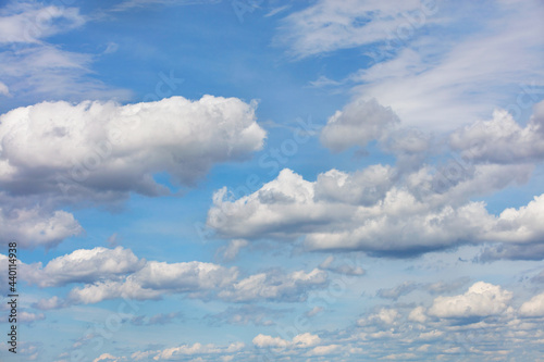 Blue sky landscape with white floating clouds.