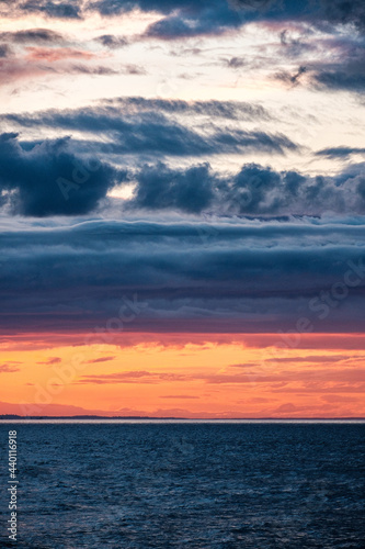 Sunset over a an overcast mountain range and ocean © Harrison