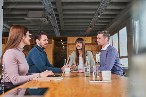 Male and female employees discussing in meeting at board room