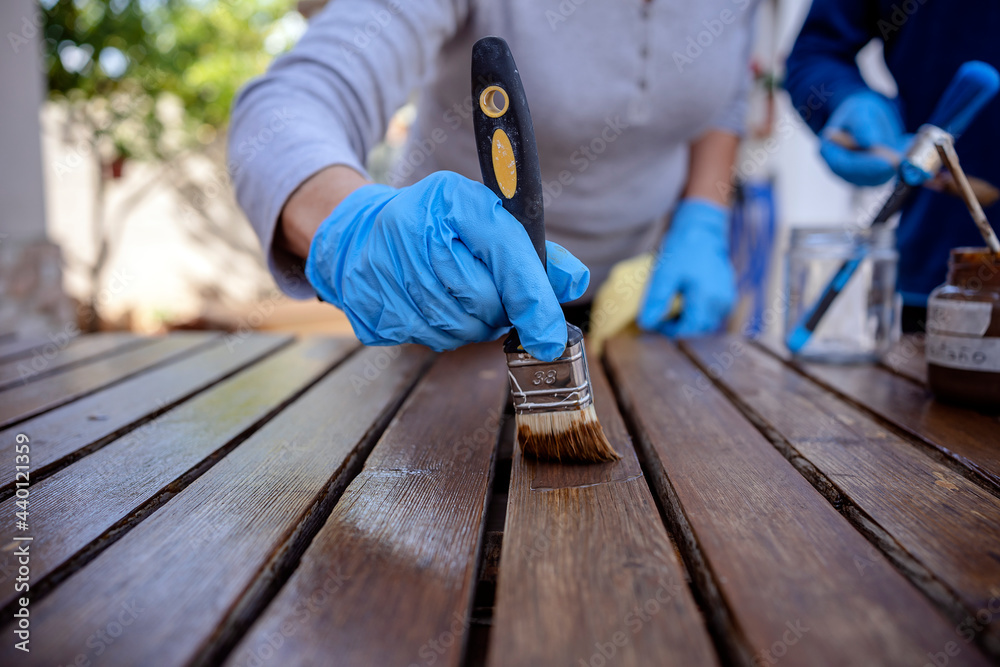 Senior woman painting wooden plank Senior woman painting wooden plank