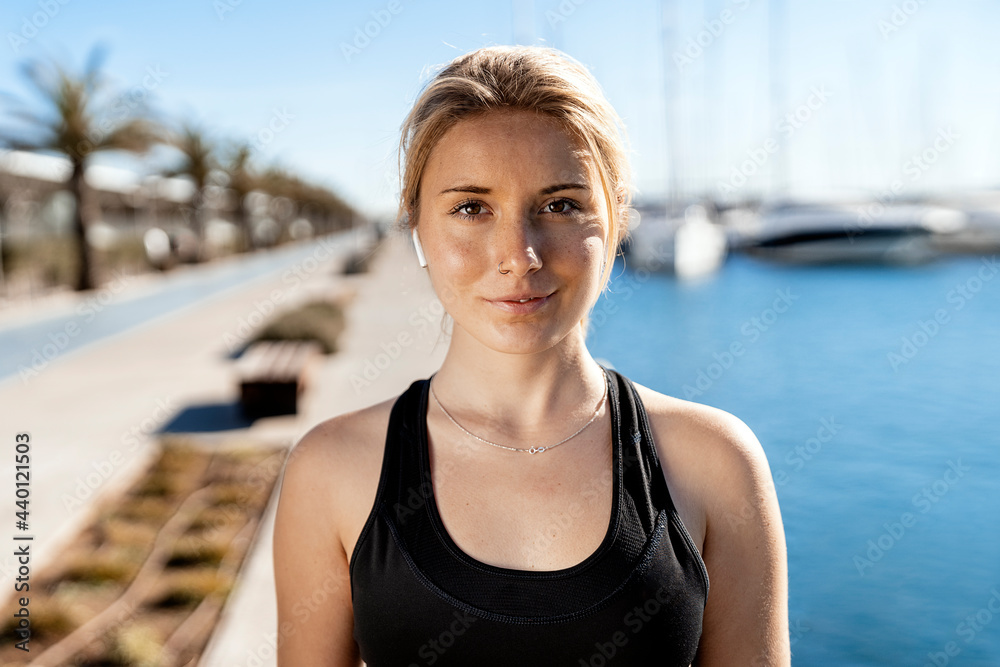 Beautiful female athlete at harbor during sunny day Beautiful female athlete at harbor during sunny day