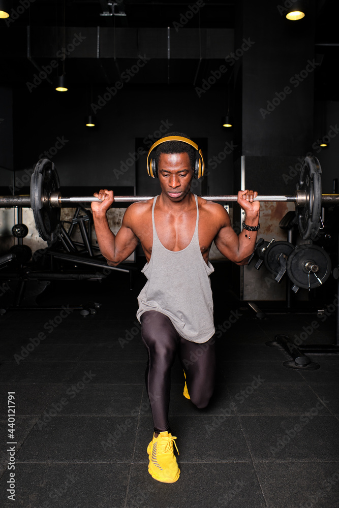 Muscular man with doing lifting barbell while doing lunge exercise at gym Muscular man with doing lifting barbell while doing lunge exercise at gym