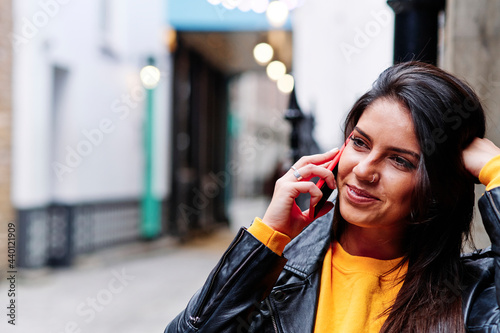 Smiling woman talking on mobile phone in city photo