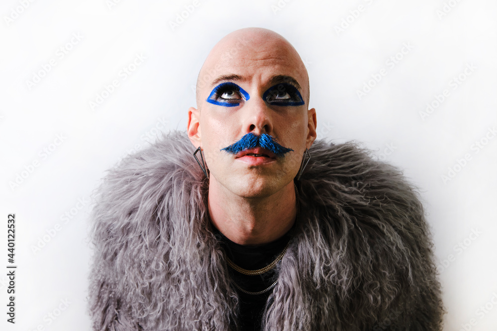 Gay man with make up looking up on white background Gay man with make up looking up on white background