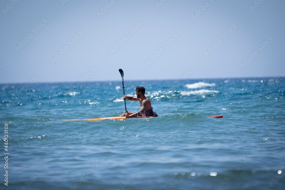 Man kayaking on the beach during summer vacation Man kayaking on the beach during summer vacation