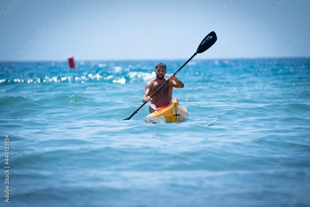 Man kayaking on the beach during summer vacation