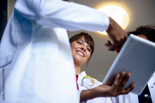 Healthcare worker explaining colleagues over digital tablet photo