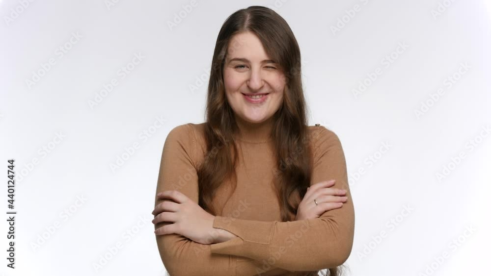 Studio portrait of smiling young woman winking and laughing in camera Studio portrait of smiling young woman winking and laughing in camera