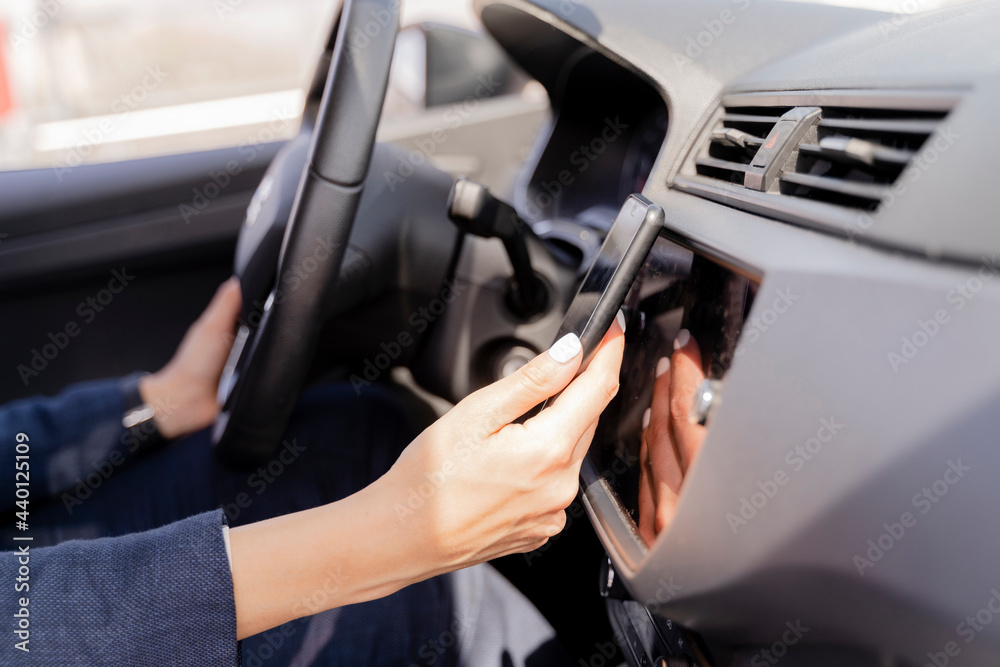 Woman using smart phone while driving car Woman using smart phone while driving car