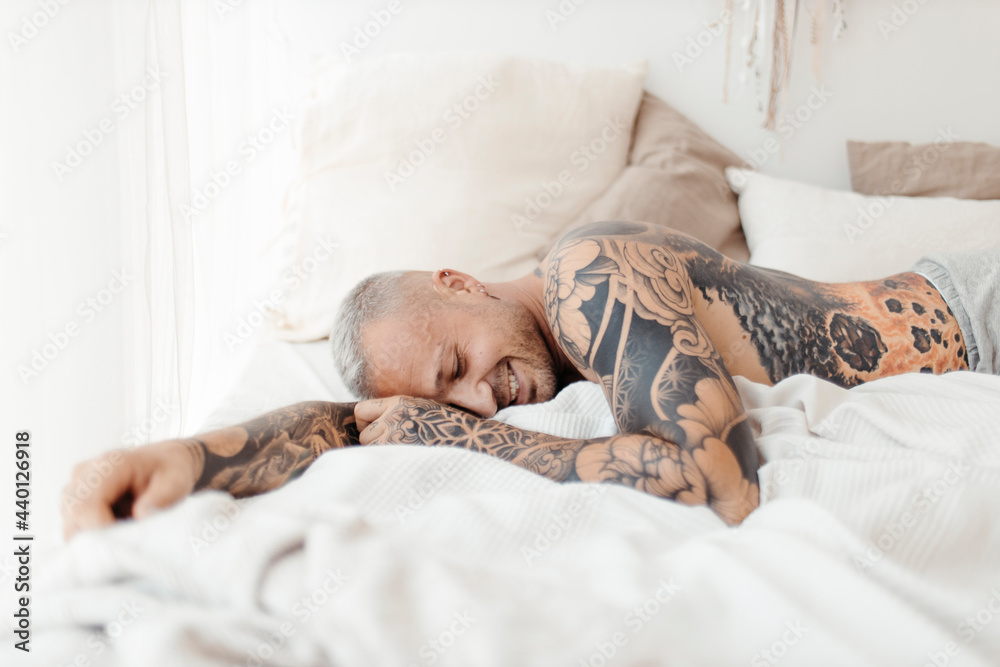 Hipster man lying on bed at home Hipster man lying on bed at home
