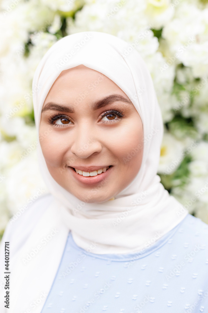 Happy woman looking away in front of white flowers decoration Happy woman looking away in front of white flowers decoration