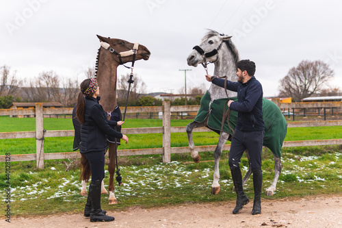 Couple rearing up horses near fence on footpath