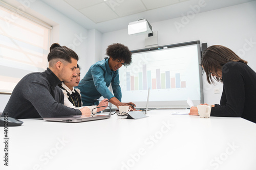 Male entrepreneur discussing with coworkers in board room at office photo
