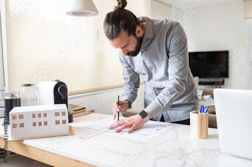 Male architect designing construction plan while working at home photo
