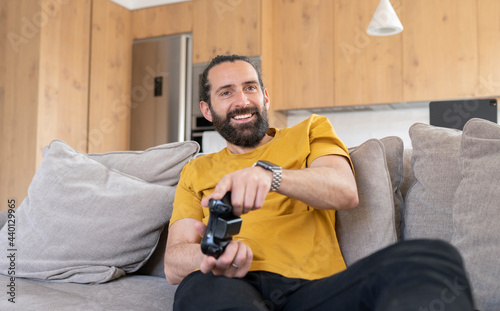 Happy man playing video game at home photo