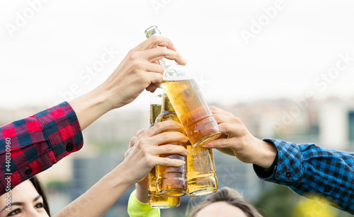 Cheerful friends toasting beer bottles