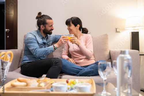Mature couple toasting glasses at hotel suite