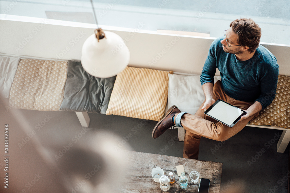 © Joseffson/Westend61 - Mature man with digital tablet sitting in cafe