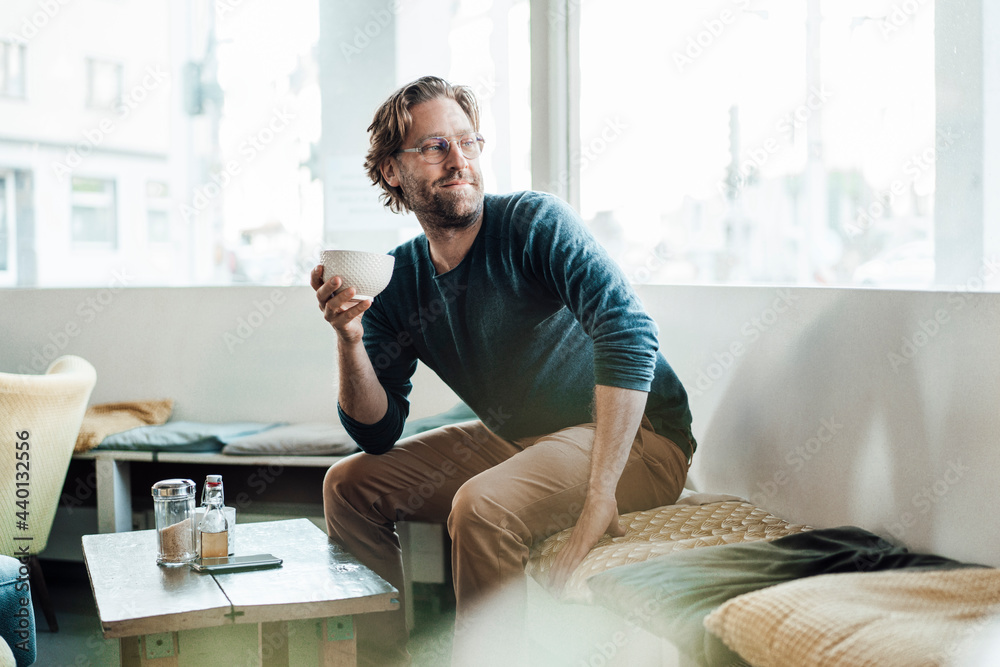 Man sitting on seat with bowl at cafe Man sitting on seat with bowl at cafe