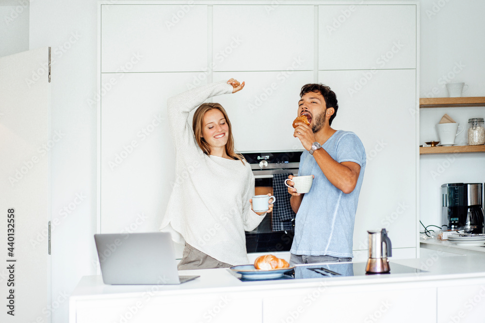 Girlfriend and boyfriend enjoying breakfast in kitchen at home Girlfriend and boyfriend enjoying breakfast in kitchen at home