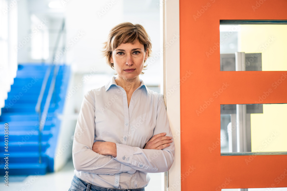 Mature businesswoman with arms crossed standing in factory Mature businesswoman with arms crossed standing in factory