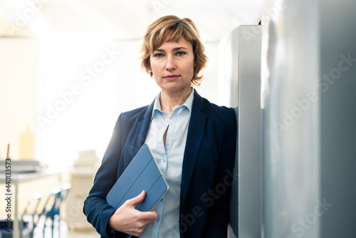 Mature manager holding digital tablet in printing factory