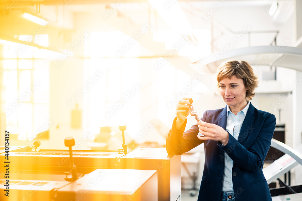 Mature expertise holding model while standing in printing workshop Mature expertise holding model while standing in printing workshop