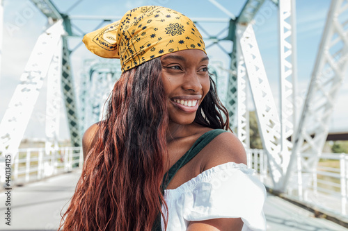 Smiling woman with bandana looking away at bridge