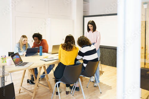 Multi-ethnic business colleagues discussing at conference table in office