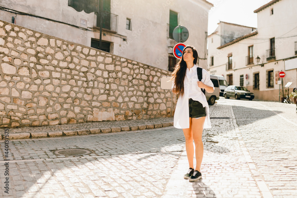 Female young tourist standing on road during sunny day Female young tourist standing on road during sunny day