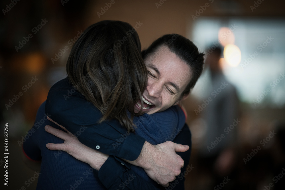 Happy man with eyes closed hugging girlfriend at home Happy man with eyes closed hugging girlfriend at home