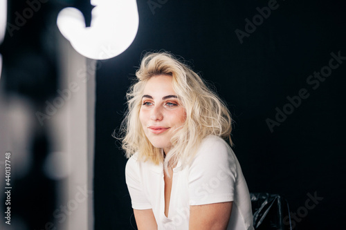 Beautiful young female model contemplating while sitting in studio photo