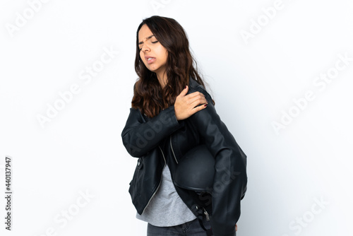 Young woman holding a motorcycle helmet over isolated white background suffering from pain in shoulder for having made an effort