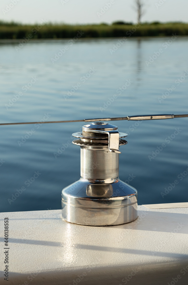 Obraz premium mooring bollard on small yacht close-up. Metal reel for rope against background of water surface